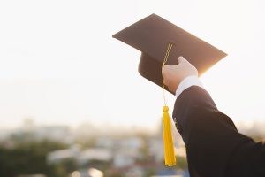 student-holds-hat-in-hand-during-commencement-success-graduates