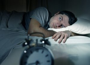 man-in-bed-with-eyes-opened-suffering-insomnia-and-sleep-disorde