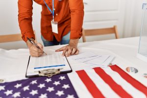 young-hispanic-man-writing-on-checklist-at-electoral-college