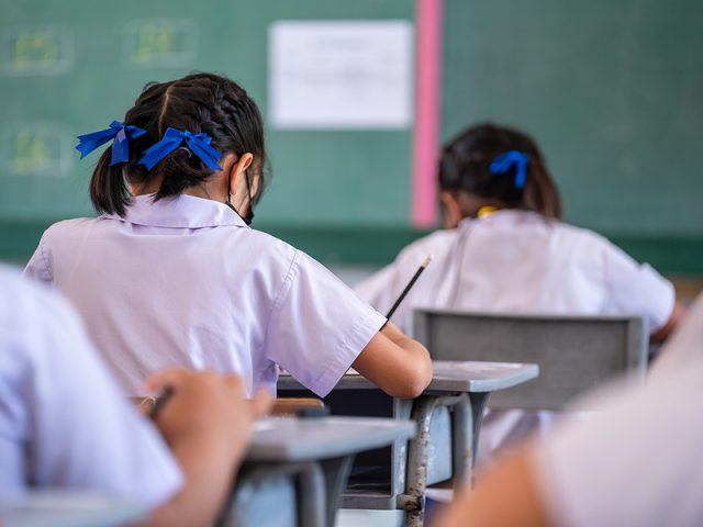 close-up-of-writing-test-in-exam-with-behind-child-asian-student