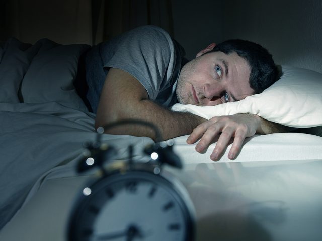man-in-bed-with-eyes-opened-suffering-insomnia-and-sleep-disorde