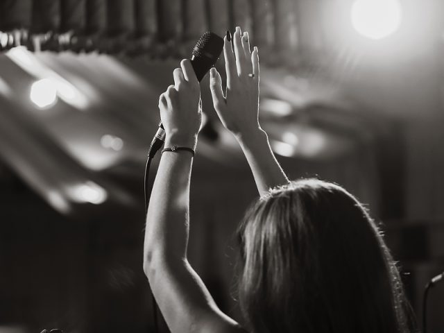 microphone-in-female-hands-close-up-black-and-white-photo-a-pu