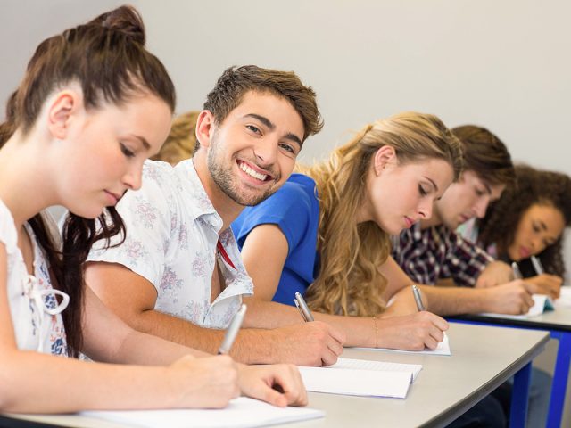 side-view-of-students-writing-notes-in-classroom