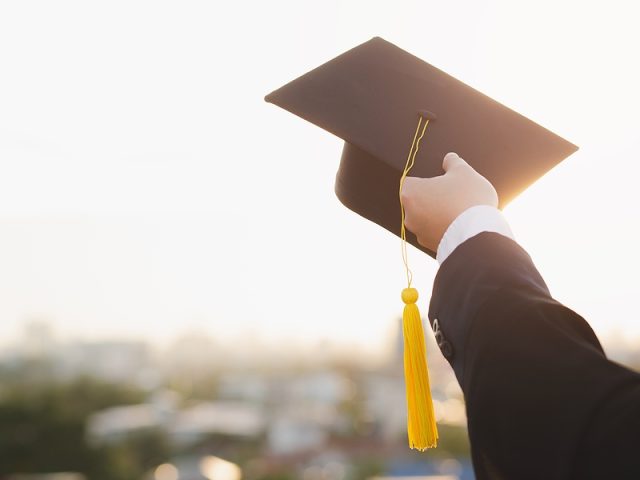 student-holds-hat-in-hand-during-commencement-success-graduates