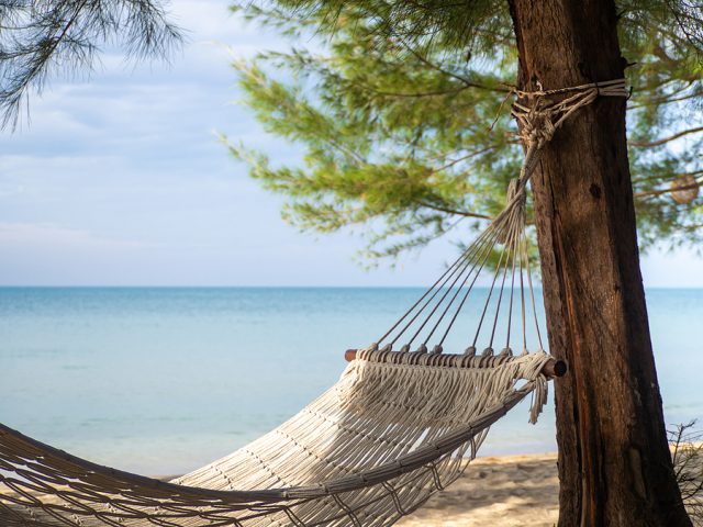 the-hammock-hung-on-the-tree-on-the-background-are-the-sea-and